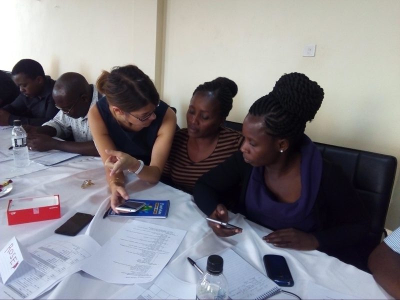 A project manager shows a group of community health workers how to use their mobile data collection app
