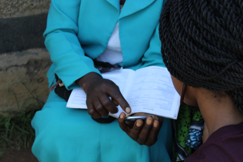 A community health worker reviews a paper form