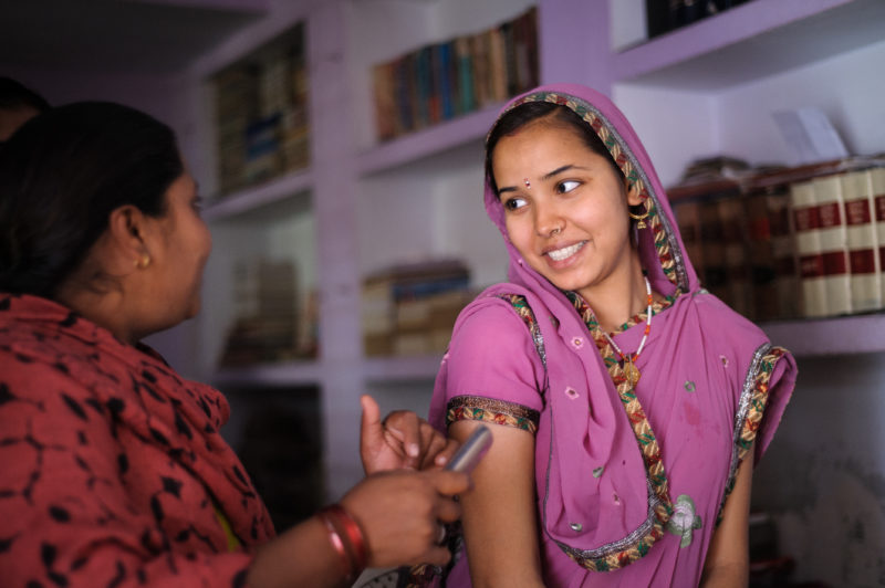 A community health worker uses a mobile data collection app to interview a recent mother