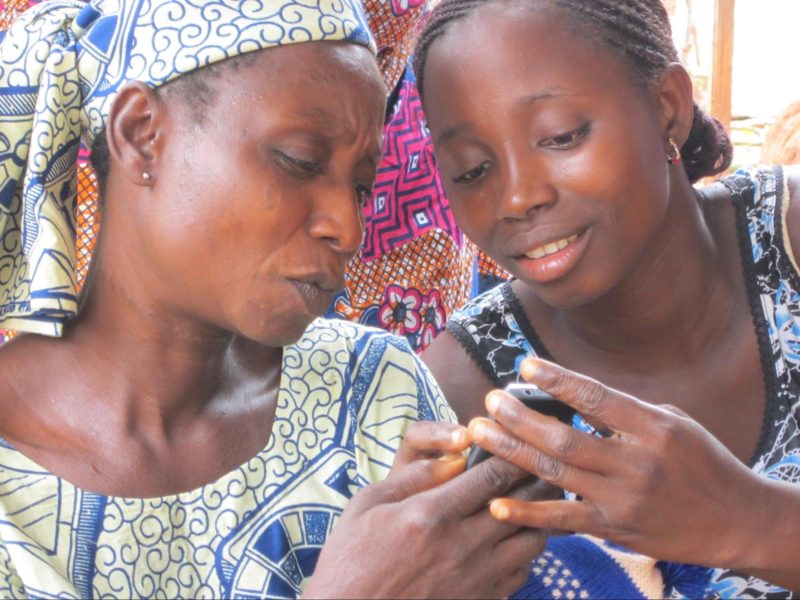 A community health worker shows an SMS she received from your mobile data collection program